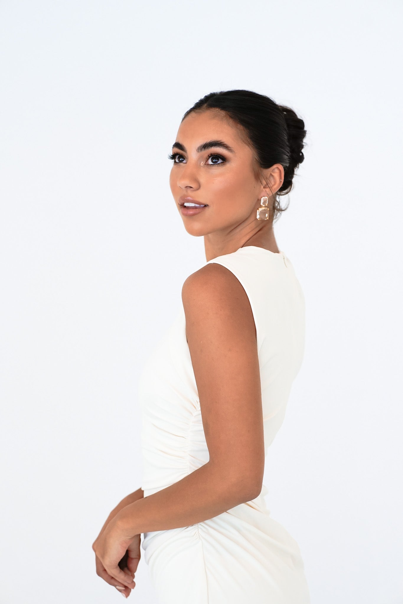 Bride with updo wearing Bianca Earrings – arms raised in playful pose, soft white backdrop