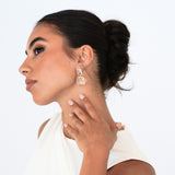 Bridal portrait with dark brunette updo – bride holding neck to showcase Bianca Earrings towards camera
