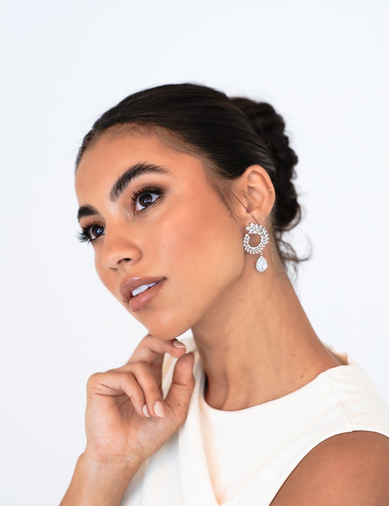 Woman wearing Lover’s Charm Earrings with hair up – showing sculptural cubic zirconia drop