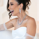 Woman wearing The Polly Set – bridal necklace and earrings with floral cubic zirconia design