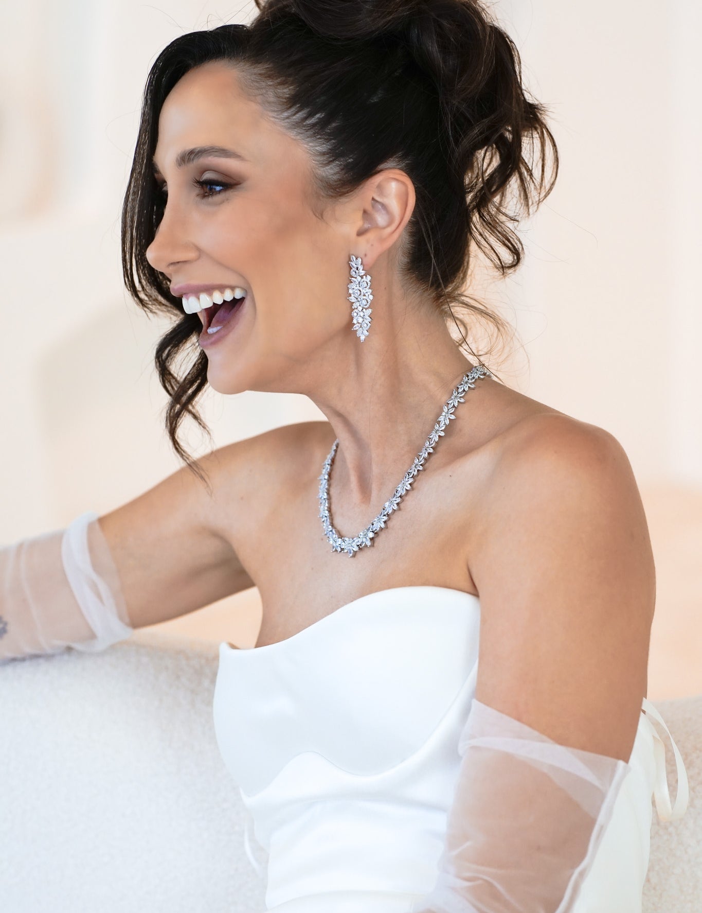 Woman wearing The Polly Set – bridal necklace and earrings with floral cubic zirconia design