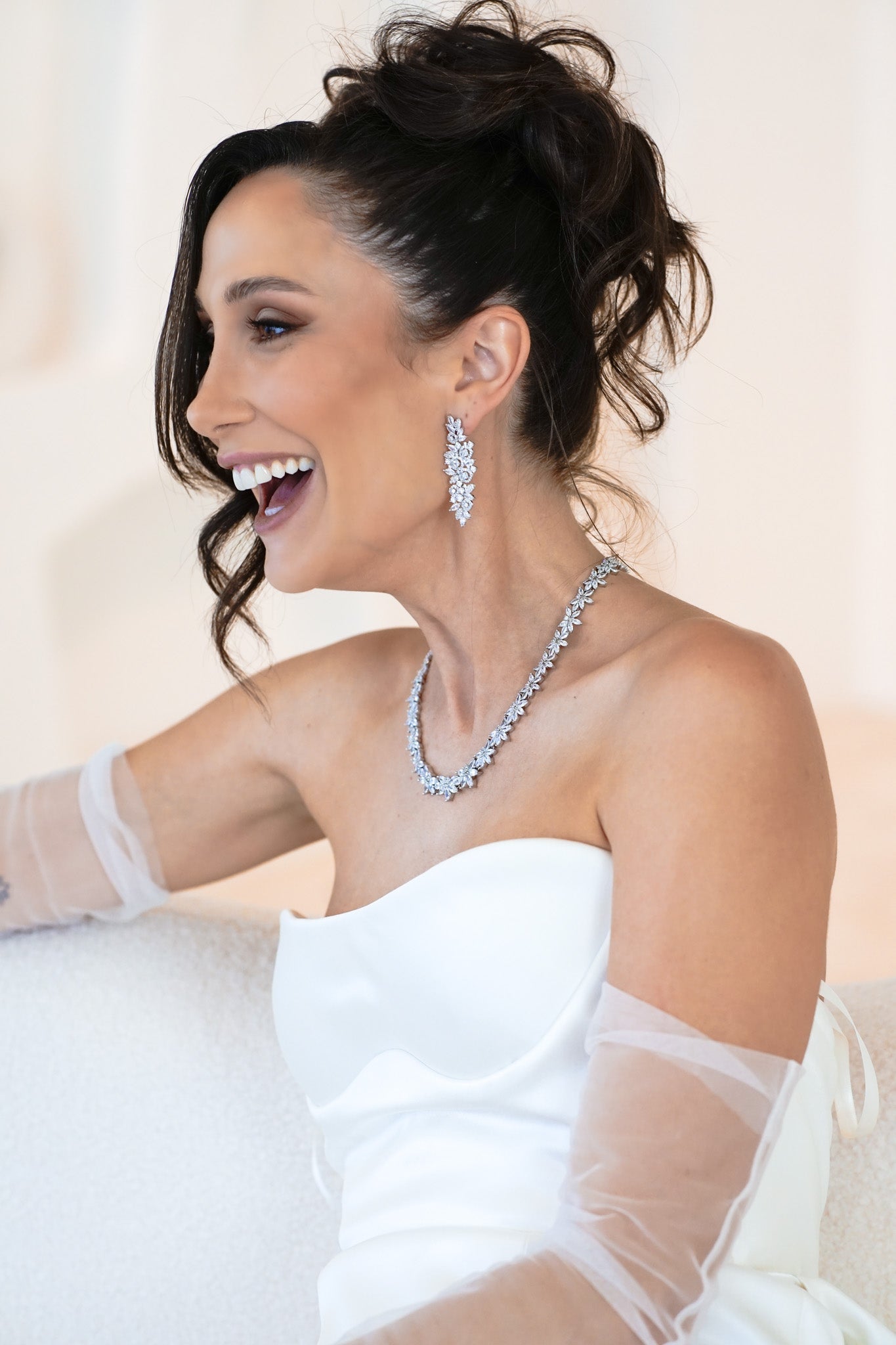 Woman wearing The Polly Set – bridal necklace and earrings with floral cubic zirconia design
