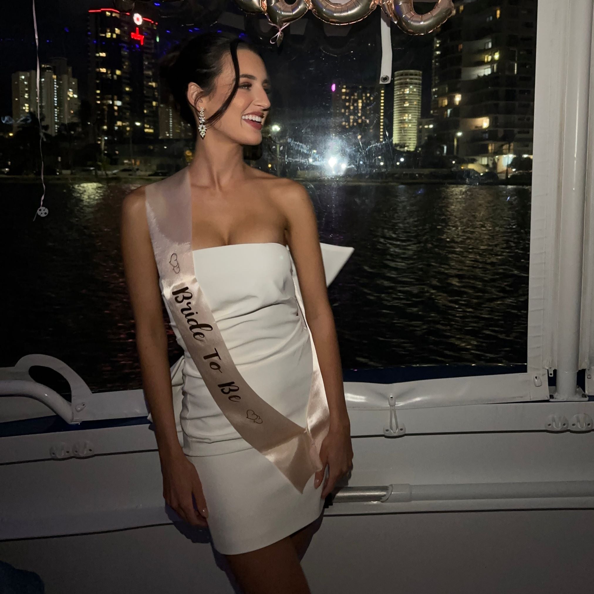 Bride to be, wearing Jessica Earrings in silver – nighttime setting, styled with white mini dress