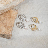 Jayda Earrings in gold and silver – flatlay on sand beside sandstone pavers