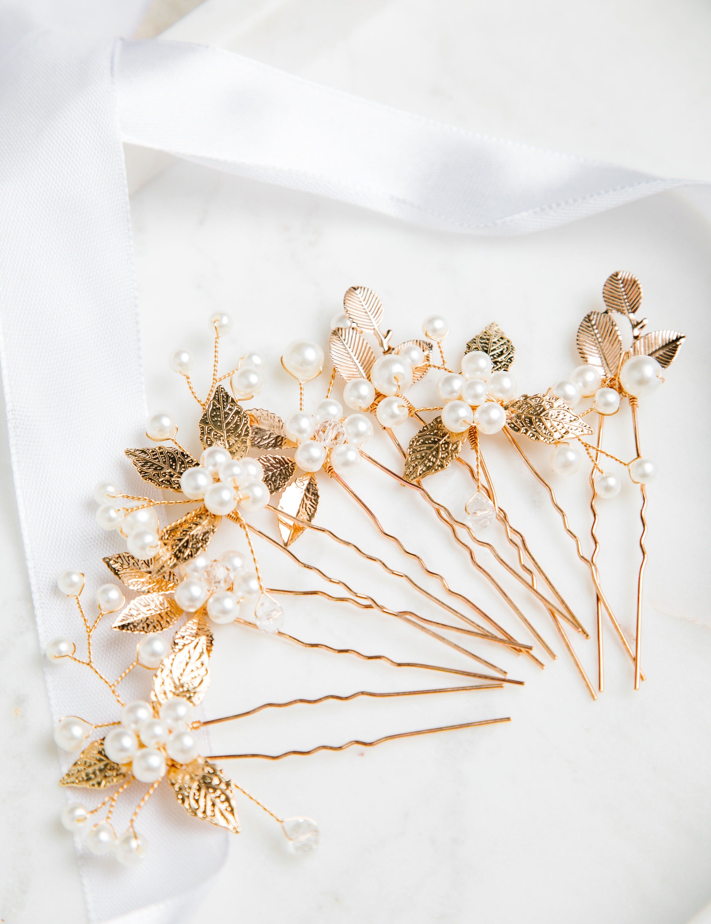 Milan Hair Pins – gold leaf and pearl hair accessories arranged on fine white cloth