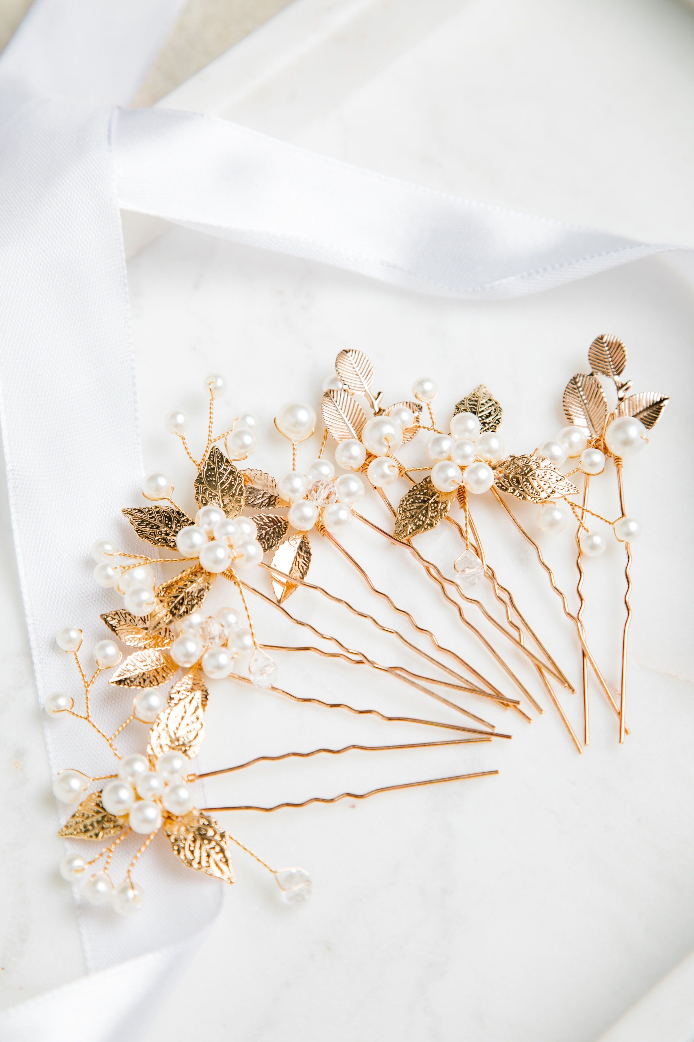 Milan Hair Pins – gold leaf and pearl hair accessories arranged on fine white cloth