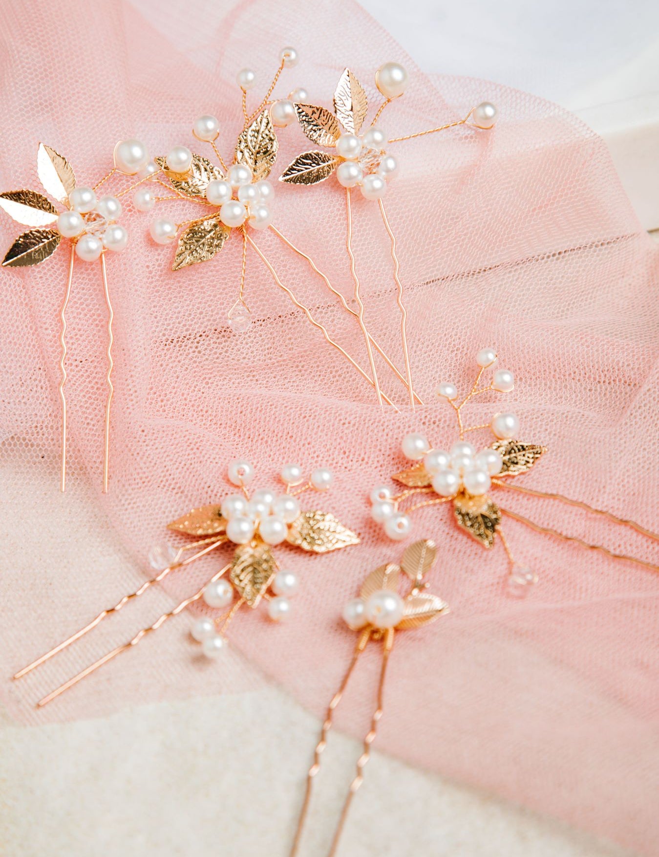 Milan Hair Pins – 7-piece set displayed on white mesh over soft pastel pink fabric