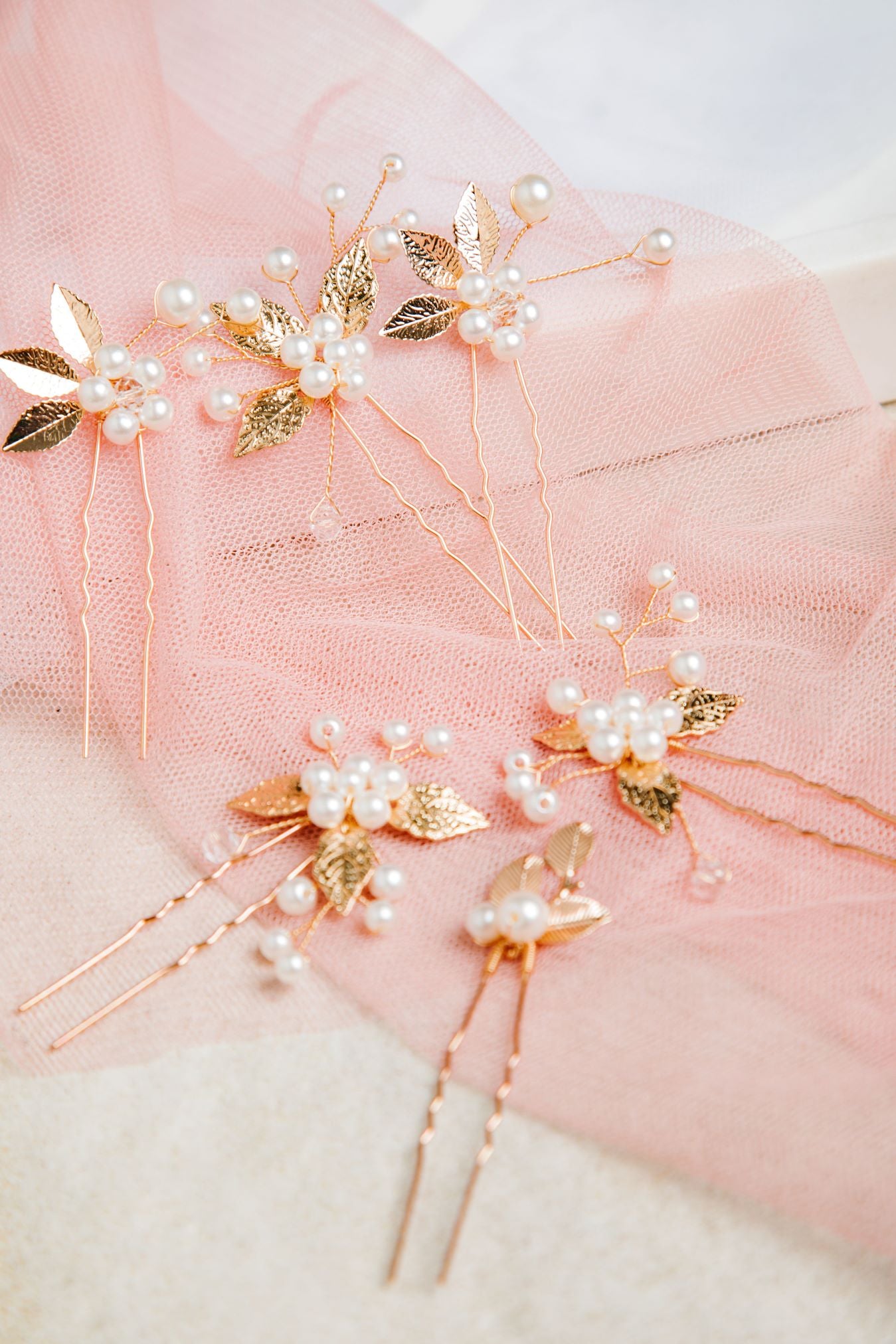 Milan Hair Pins – 7-piece set displayed on white mesh over soft pastel pink fabric