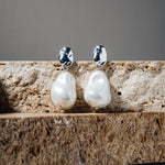 Kat Earrings – freshwater pearl drop earrings in silver on stacked brown pavers and grey background