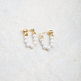 Kristy Earrings on textured felt background, softly lit to highlight pearl detail and gold stud