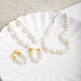Kristy Earrings and matching pearl necklace displayed on a scalloped porcelain plate beside a similar earring style – showcasing a coordinated jewellery set