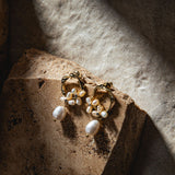 Jayda Earrings in gold – illuminated by dramatic sunlight, styled atop sandstone paver with soft sand background