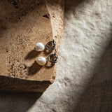 Peyton Earrings in silver – placed on a sandstone paver with dramatic lighting and a sand-toned textured backdrop
