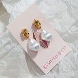 Kat Earrings in gold on Kymond & Co pink card, sitting on crinkled translucent gift wrap paper