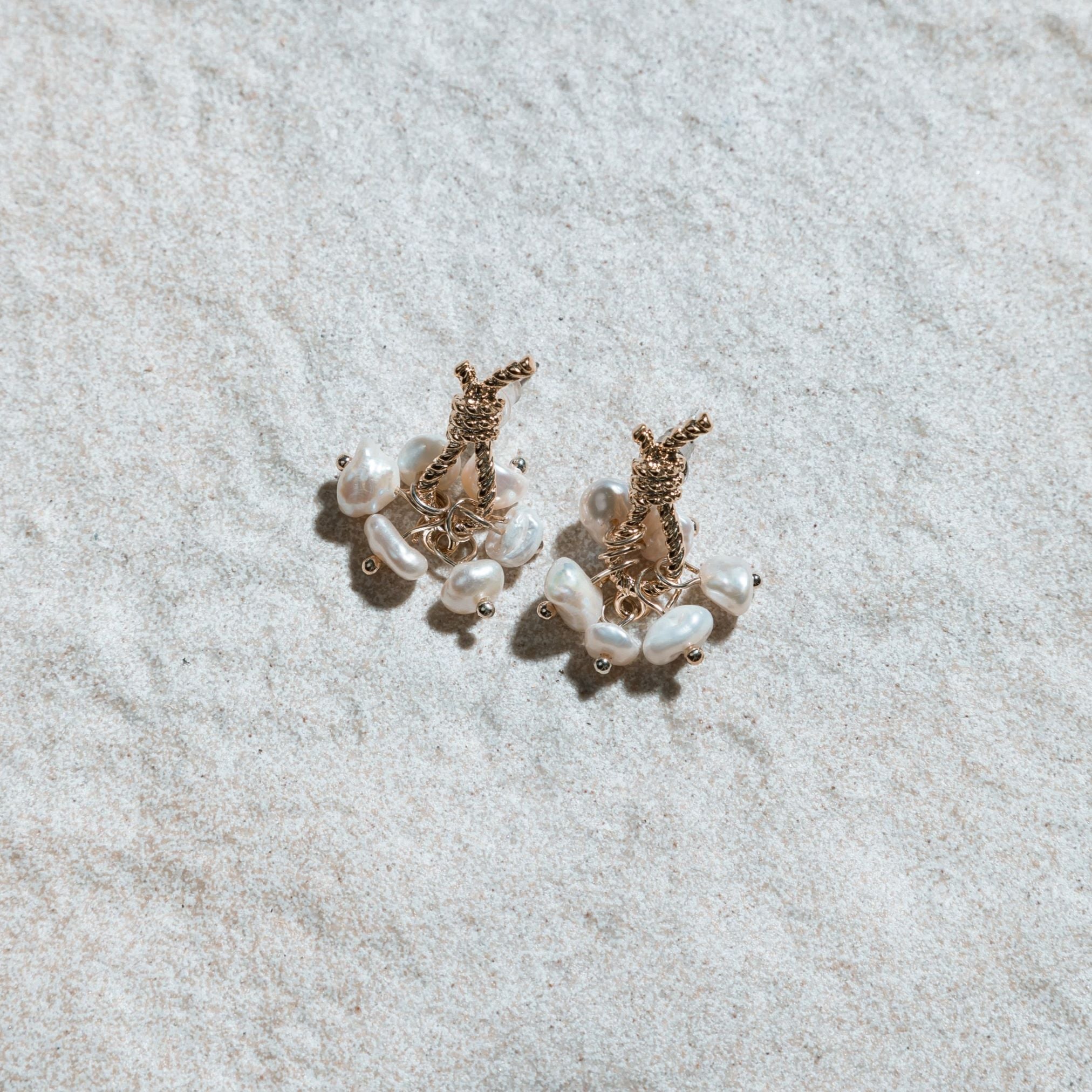 Loretta Earrings – sculptural pearl drop earrings displayed on mottled sand-coloured felt background