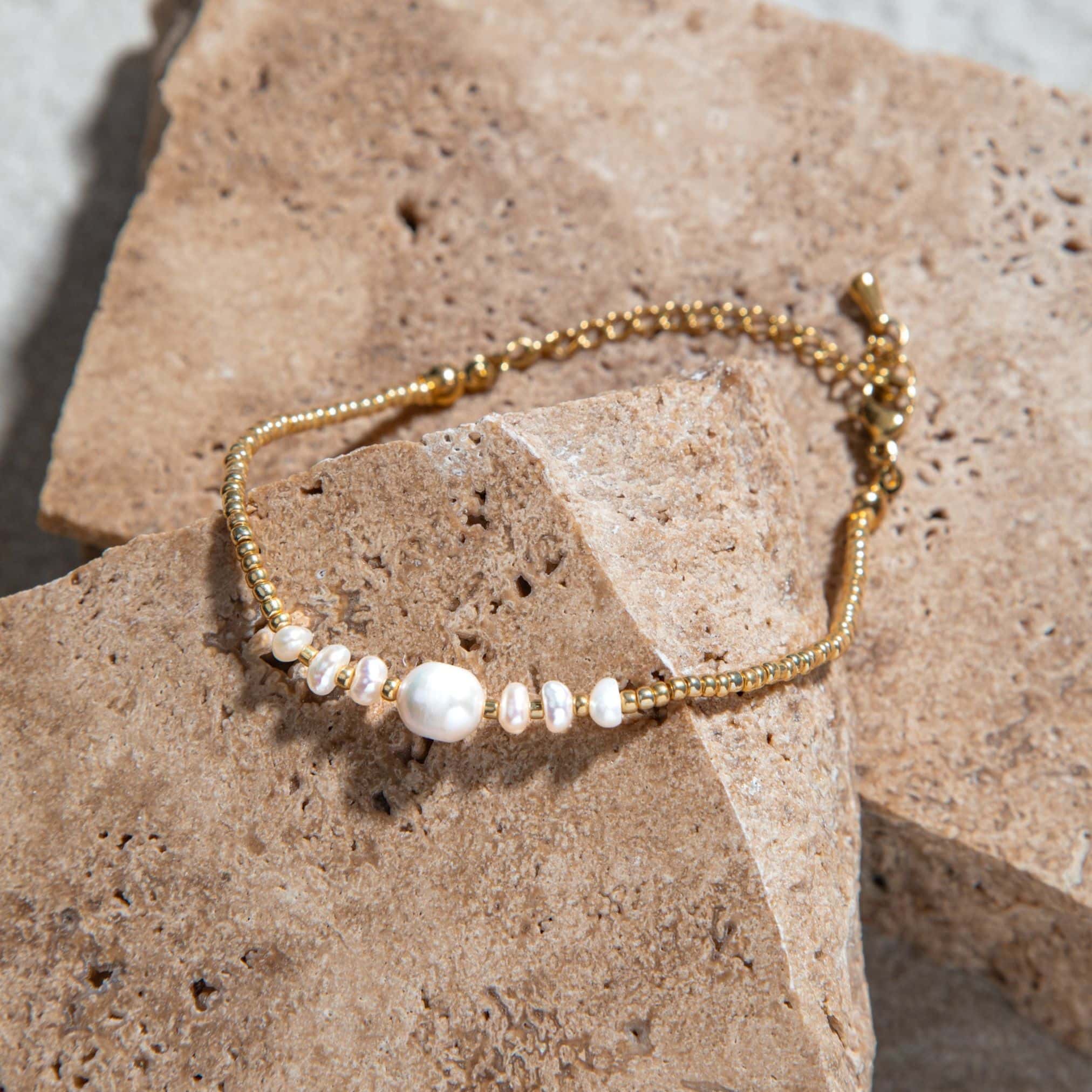 Pearl Bracelet – gold pearl bracelet with beaded detail on stone background