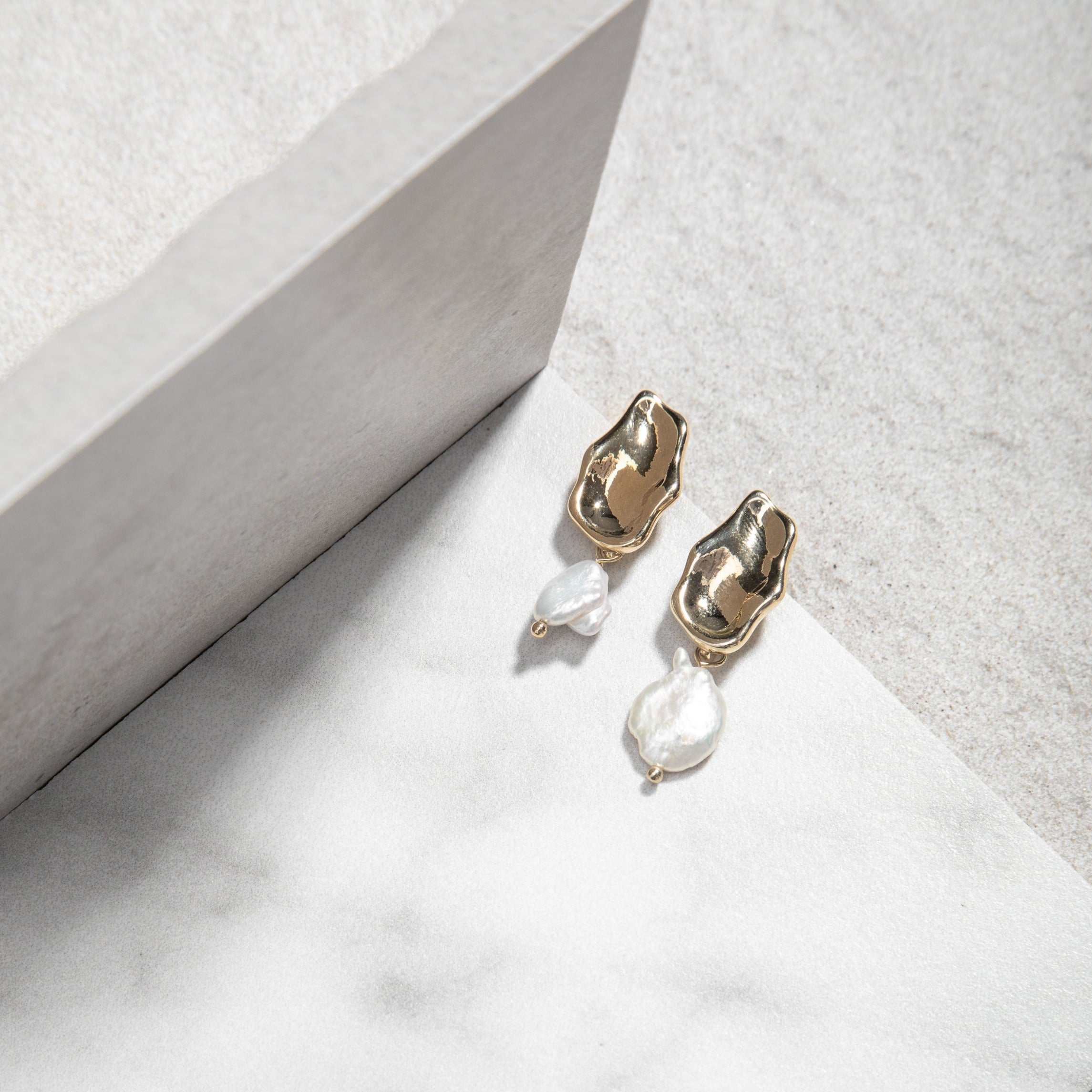 Leah Earrings – freshwater pearl drop earrings on white tile with vertical tile backdrop, soft grey felt background