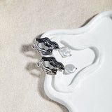 Destiny Earrings – sculptural gold and pearl drop earrings on organic porcelain dish with sand-coloured felt background