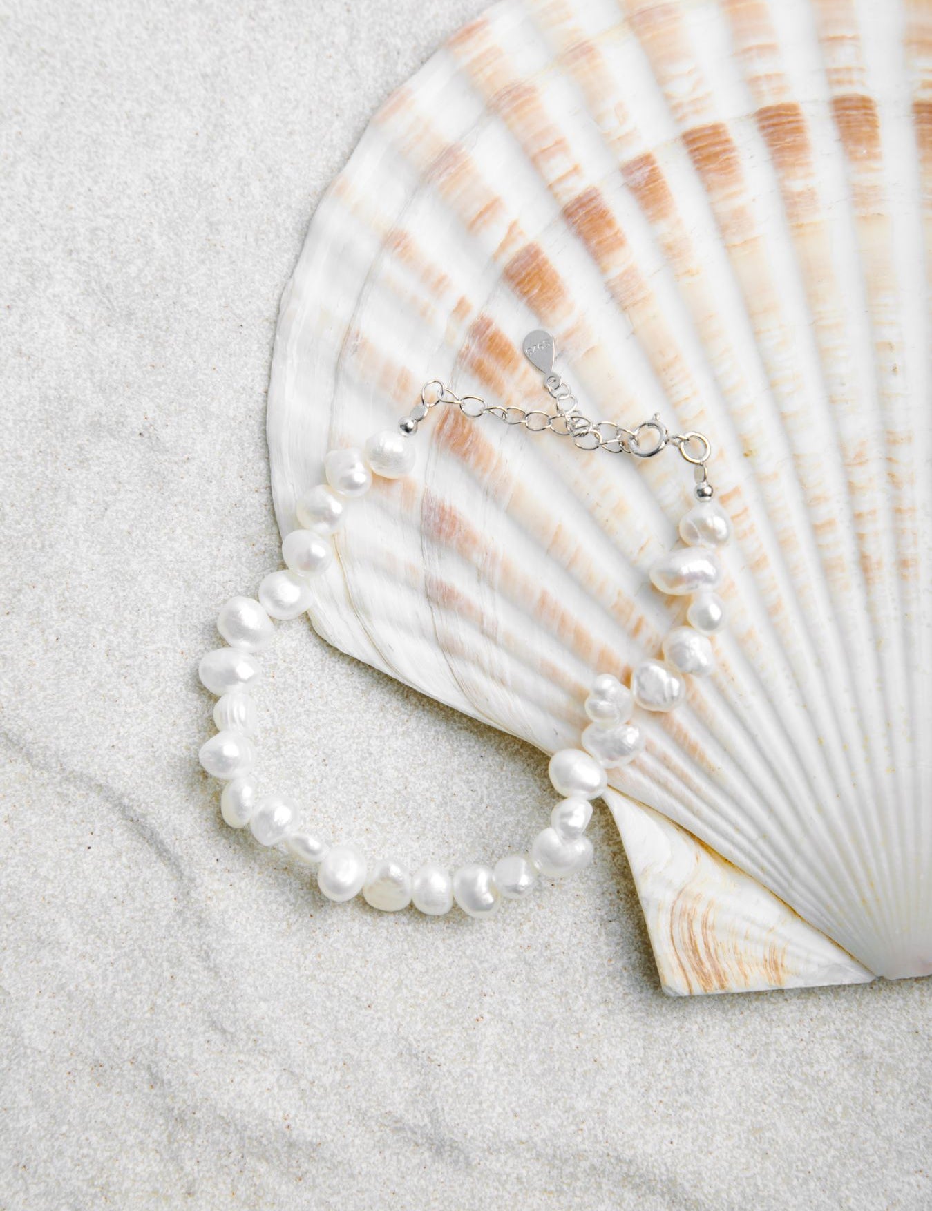 Aurora Bracelet – freshwater pearls on sterling silver chain styled on a clamshell and sand