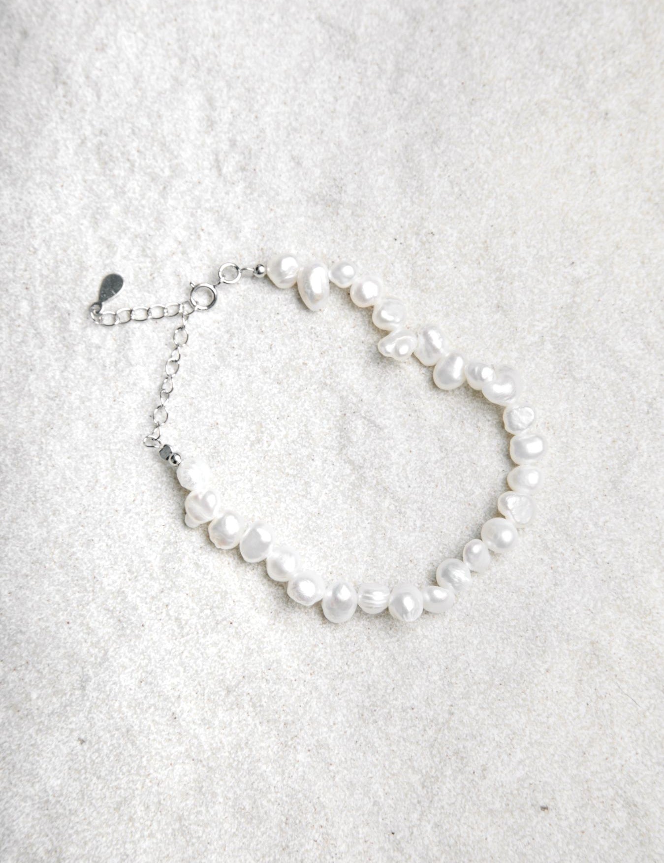 Aurora Bracelet – freshwater pearls on sterling silver chain styled on sand coloured background