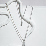 The Sophia Set necklace – molten-effect silver drop pendant on sculptural white background