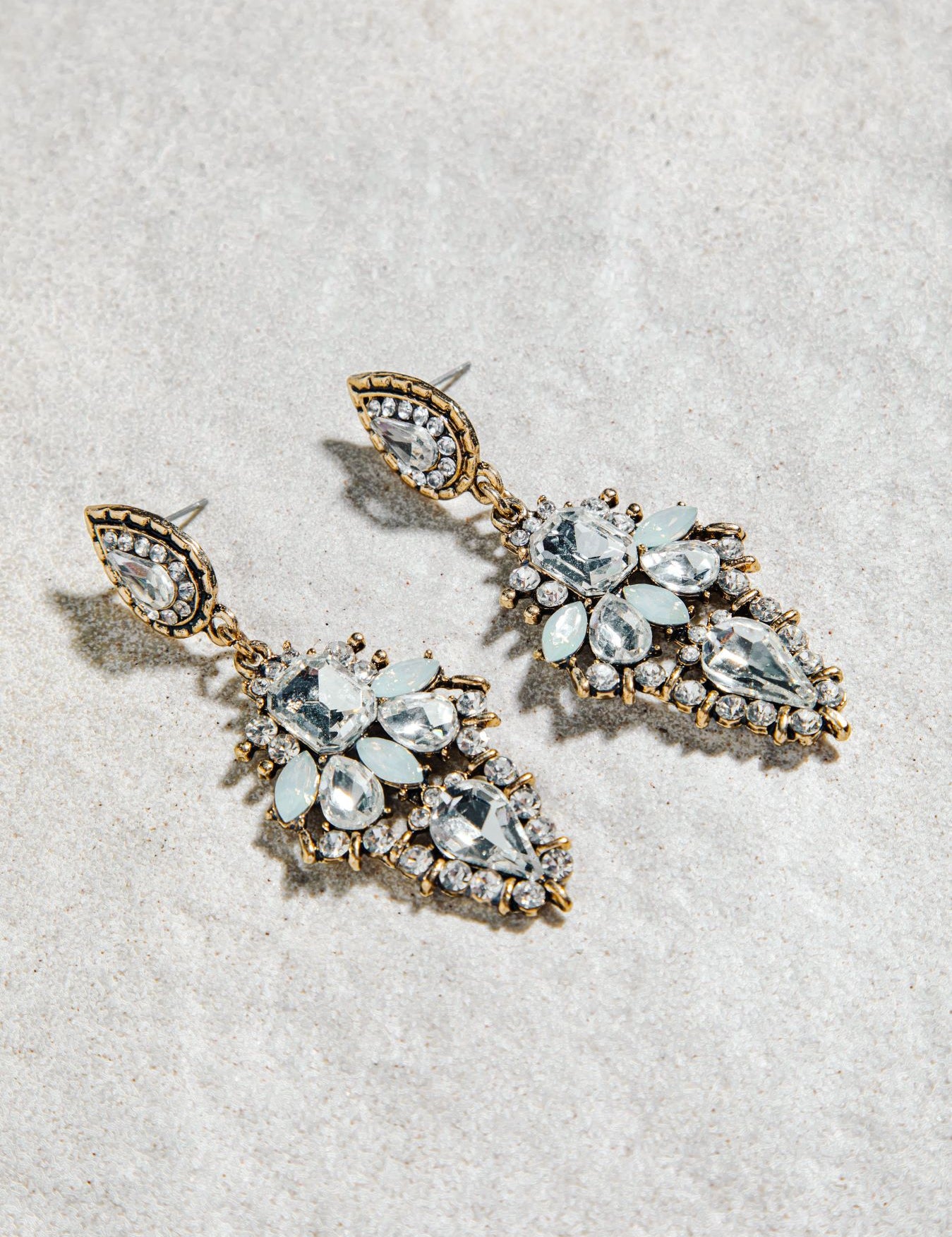 Alexia Earrings – prong-set vintage drop earrings in white and aqua colourway on white textured background