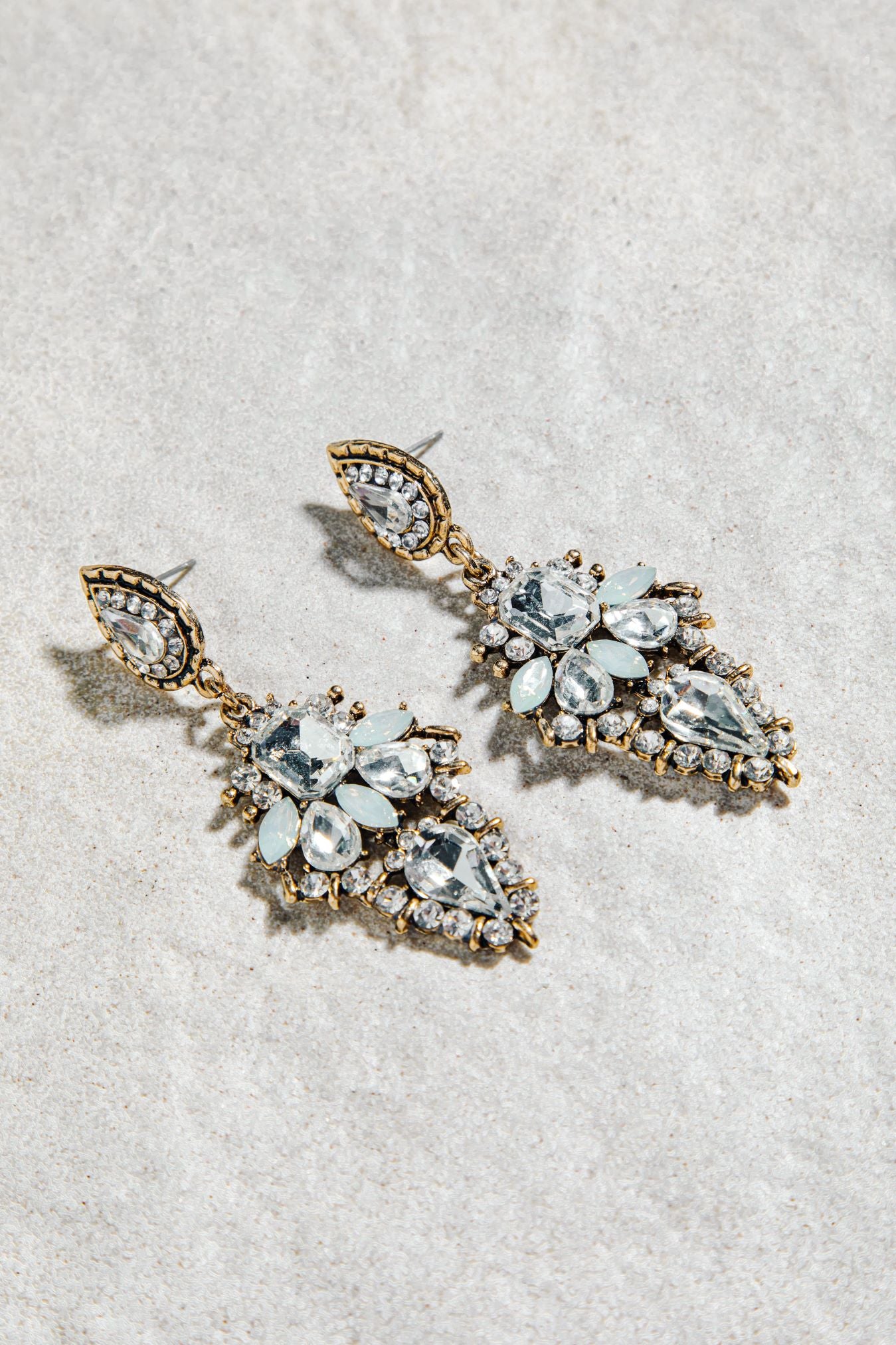 Alexia Earrings – prong-set vintage drop earrings in white and aqua colourway on white textured background