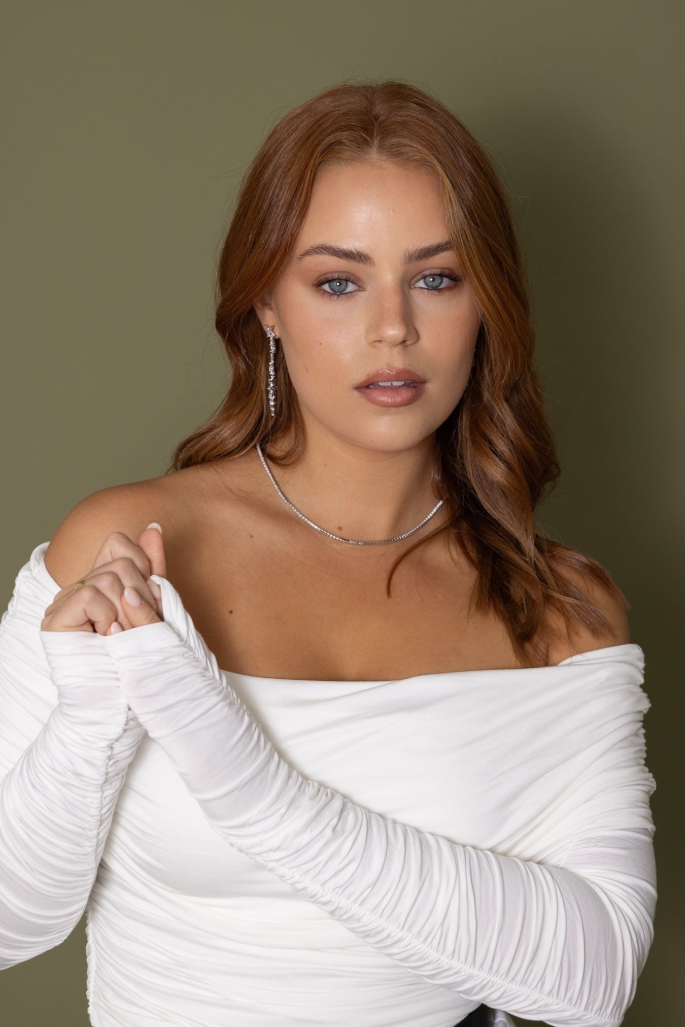 Woman wearing Jessica Earrings in silver – styled with white ruched off-shoulder top