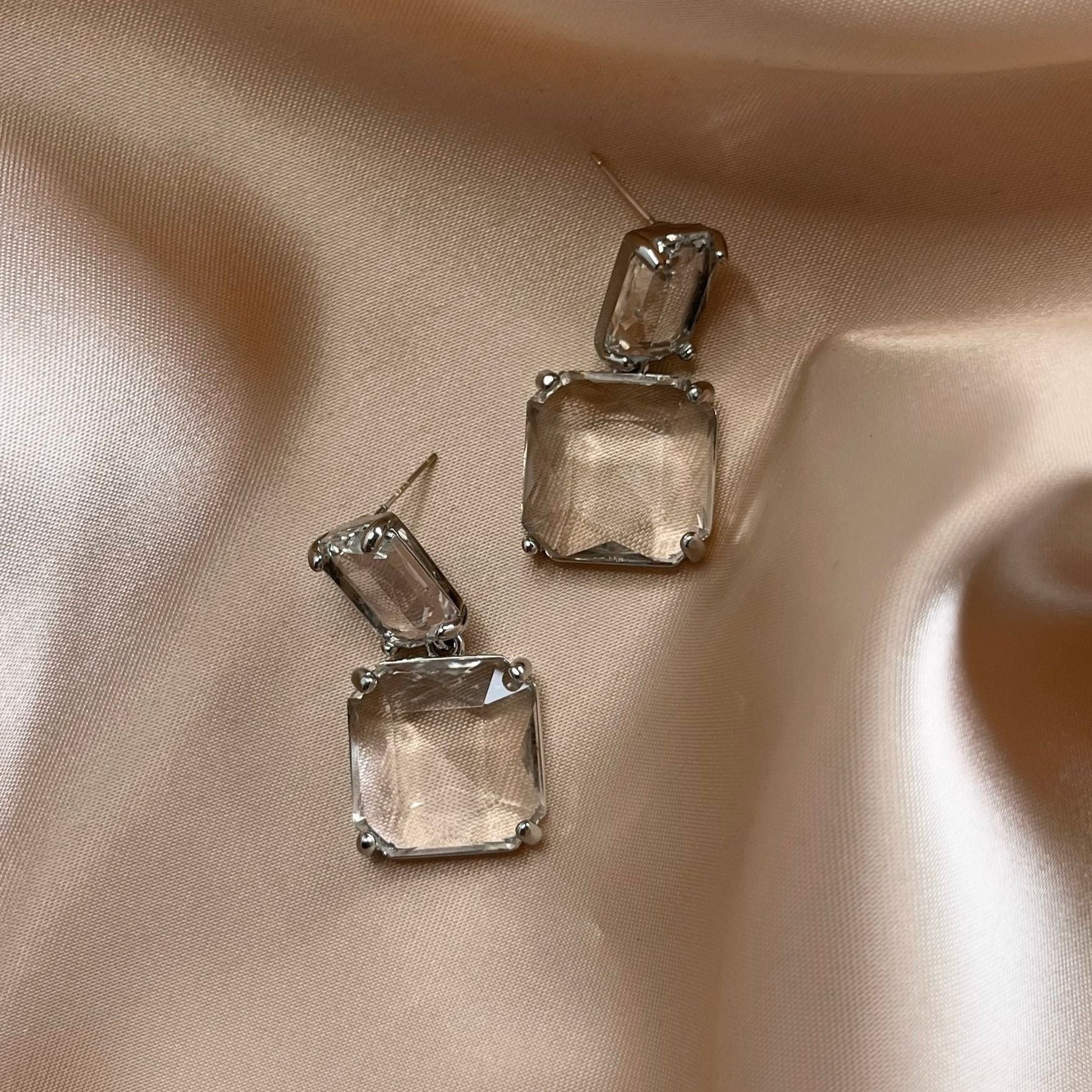 Silver Bianca Earrings on lustrous off-white and bronze-toned cloth – soft shine and sculptural clarity