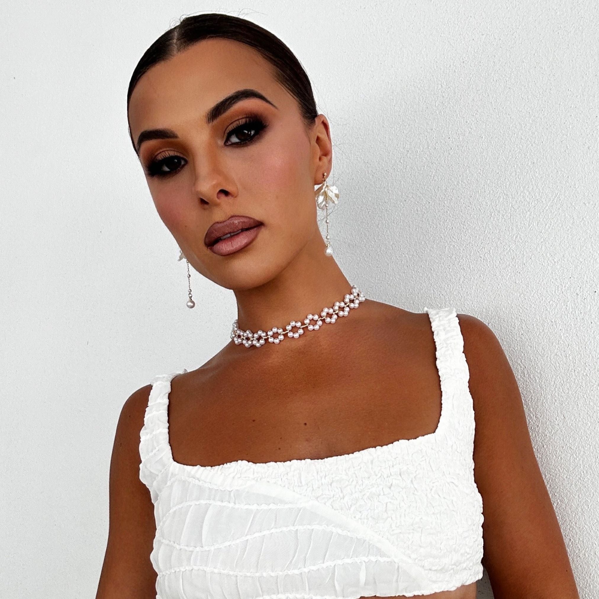 Model in white top showing the versatile Anika Earrings for casual wear