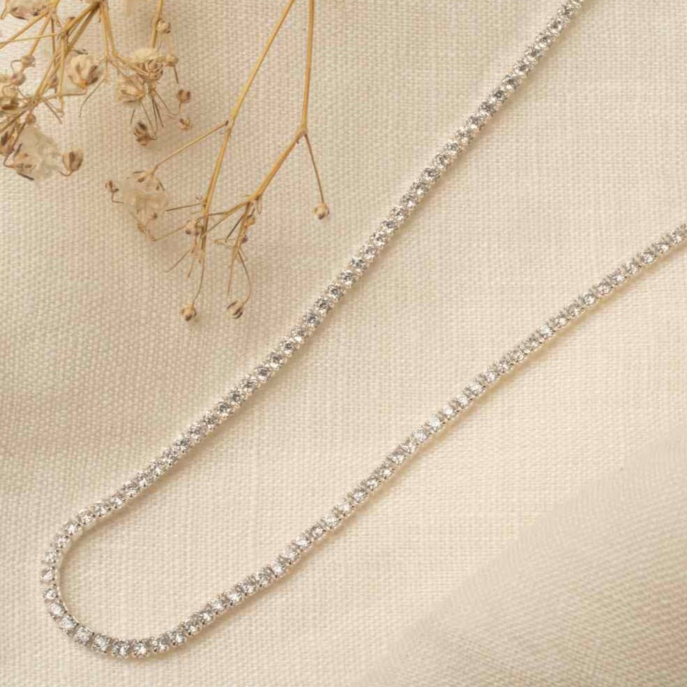 Classic Tennis Necklace in silver – flatlay on linen with dried flowers