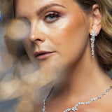 Woman wearing The Simone Set – close-up of floral bridal earrings and necklace with marquise and round-cut cubic zirconia stones
