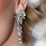 Close-up of Marlo Earrings on bride’s ear – crystal sparkle with soft bokeh light in foreground