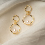 Sara Earrings – imitation pearl drop earrings on soft linen, highlighting lustrous pearl and dimensional gold finish