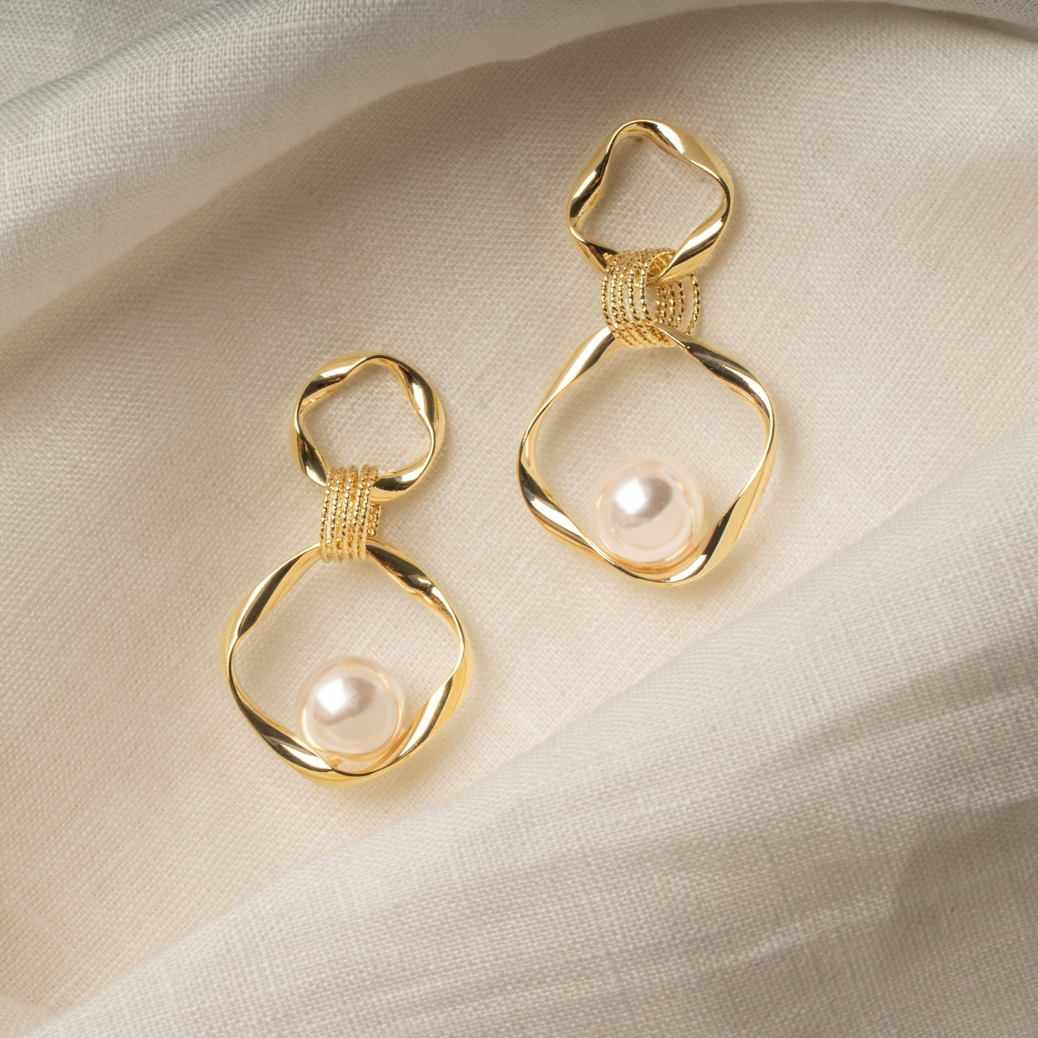 Sara Earrings – imitation pearl drop earrings on soft linen, highlighting lustrous pearl and dimensional gold finish